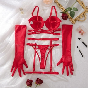 Detalle plano de un conjunto de lencería rojo de cuatro piezas con textura de serpiente