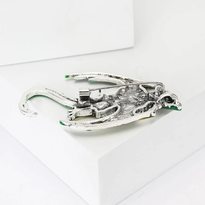 Detailed back view of silver dragon brooch with green enamel and sturdy metal pin clasp