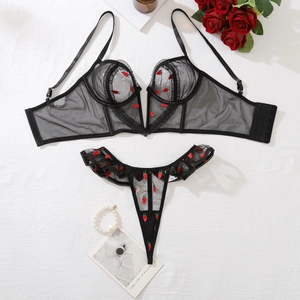 Vue à plat de l'ensemble lingerie en résille noire avec broderie fraise rouge et dentelle