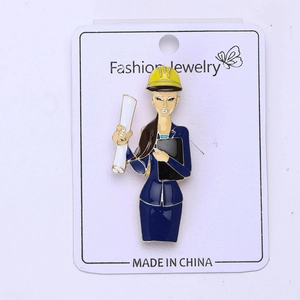 Detail view of cartoon female engineer brooch with safety hat on display card