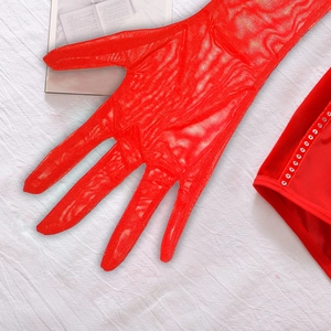 Détail des gants en dentelle rouge et du bustier en velours avec paillettes argentées