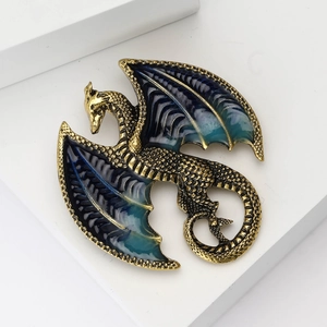 Detail of western dragon brooch with blue enamel wings and golden metallic scales