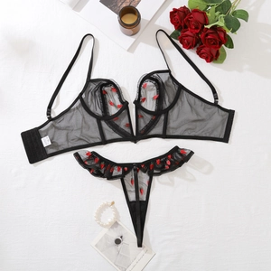 Détail d'un ensemble de lingerie en mesh noir avec broderie fraise et bords à volants