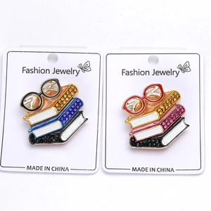 Detailed macro view of creative enamel book stack pins with sparkling rhinestones and glasses
