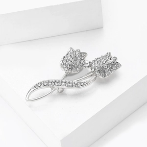 Détail d'une luxueuse broche tulipe argentée ornée de strass blancs scintillants et pavés