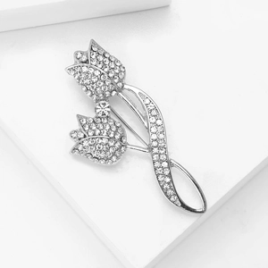 Gros plan détaillé d'une luxueuse broche tulipe sertie de strass sur un support blanc