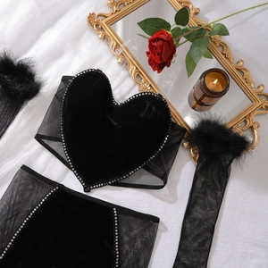 Détail de lingerie bustier cœur en velours noir avec strass et manches à plumes
