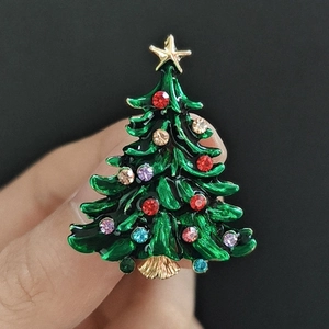 Close-up of enamel Christmas tree brooch with colorful rhinestones and gold star detail
