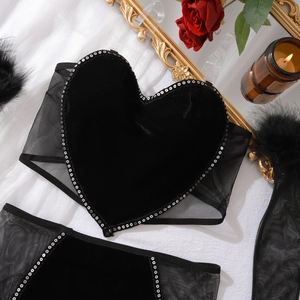 Détail d'un ensemble de lingerie coeur en velours avec paillettes et plumes noires