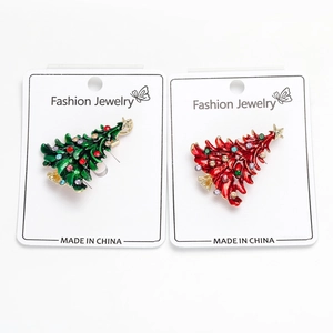 Close-up of enamel Christmas tree brooches with colorful rhinestones in red and green