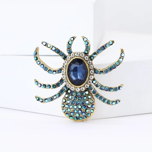 Detailed macro view of vintage spider brooch with blue gemstones and rhinestones