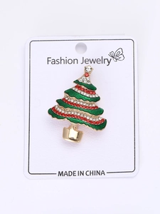 Dettaglio di una spilla a forma di albero di Natale con smalto verde e strass