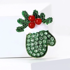Christmas glove brooch with green rhinestones and red pearls on white geometric platforms