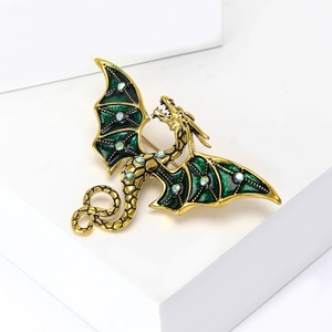 Détail des ailes en émail vert et strass sur la broche en forme de dragon doré