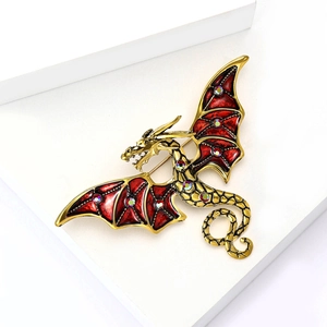 Détail d'une broche dragon en émail rouge avec strass multicolores sur alliage doré poli