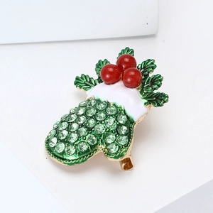 Detailed view of Christmas glove brooch with green rhinestones and enamel winter holly details