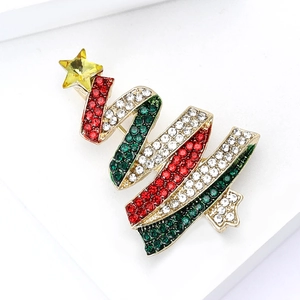 Christmas tree brooch with gold base and red green white crystals on white stand