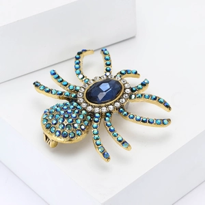 Detail of vintage gold spider brooch with oval blue gemstone and rhinestones
