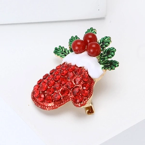Close-up of Christmas glove brooch with red rhinestones and green enamel leaf details