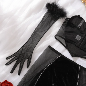 Détail d'un ensemble de lingerie sexy en maille noire avec plumes et velours à paillettes