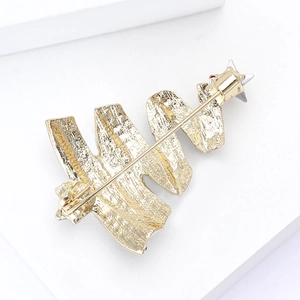 Detail view of gold alloy Christmas tree brooch back with secure pin and rotating safety clasp