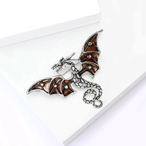 Détail macro d'une broche dragon avec émail chocolat et strass multicolores