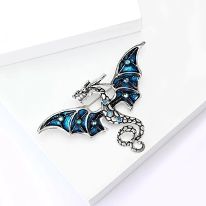 Détail d'une broche dragon en émail bleu avec strass colorés sur une base en argent