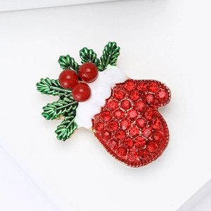 Detail of Christmas glove brooch with red rhinestones and holly berry green leaves