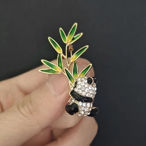 Detail showing panda and bamboo brooch with white rhinestones and green enamel