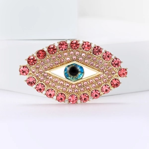 Λεπτομέρεια macro από καρφίτσα Evil Eye με ροζ στρας σε χρυσή μεταλλική βάση