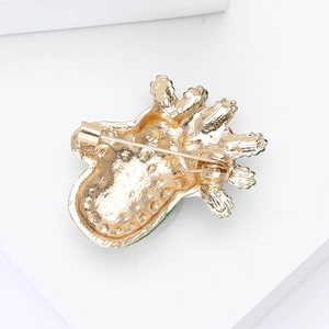 Detailed back view of the golden brooch showing the needle pin and secure safety rotating clasp
