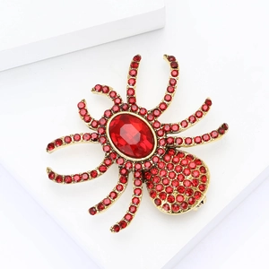Macro shot of spider brooch featuring detailed red rhinestones and oval crystal