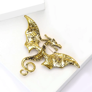 Vue détaillée de la broche dragon dorée vintage avec écailles et ailes ciselées