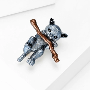 Detailed close-up of a gray enamel cat brooch on a white minimalist display stand