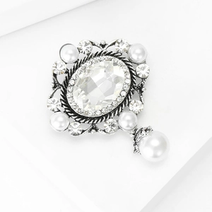 Dettaglio spilla vintage argento con gemma ovale trasparente e ciondolo di perla bianca