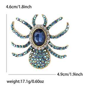 Spider brooch with large blue gemstone and sparkling colorful rhinestones on gold base