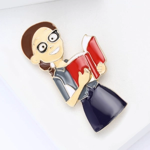 Vintage Emaille-Lehrerbrosche mit Cartoon-Dame beim Lesen eines Buches in Goldoptik