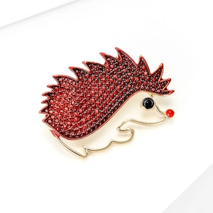 Detailed macro view of a red enamel hedgehog brooch with golden metallic outlines