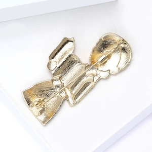 Detailansicht des sicheren rückseitigen Nadelverschlusses und der goldenen Textur der Brosche