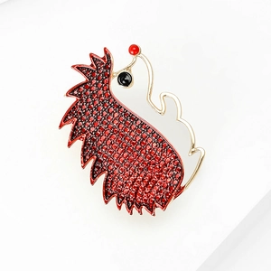 Close-up of a creative hedgehog brooch with red rhinestones and golden alloy plating