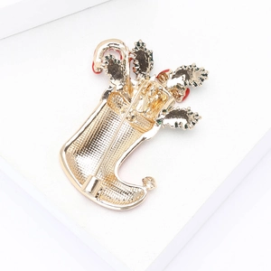 Detailed close-up of a Christmas stocking brooch with red candy canes and a gold pin back