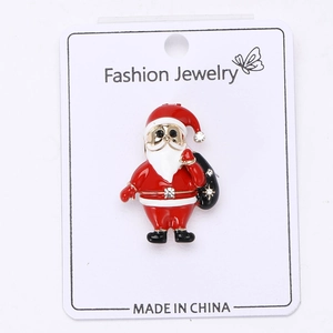 Primer plano detallado de un broche de Papá Noel con esmalte colorido y pedrería brillante