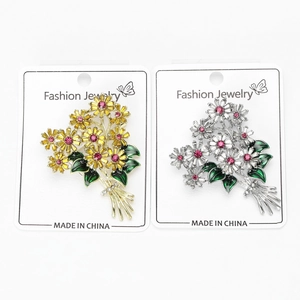 Detailed view of daisy bouquet brooches with colorful rhinestones on jewelry card
