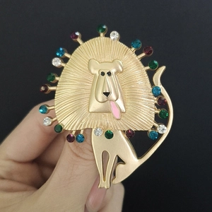 Detail of lion brooch featuring colorful rhinestones and gold metal finish on hand