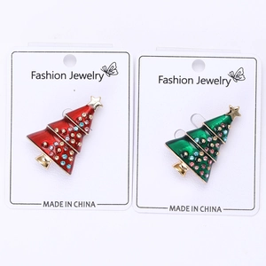 Detail of red and green enamel Christmas tree brooches with rhinestones and gold star