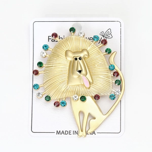 Macro detail of golden lion brooch with colorful rhinestones on a white card display