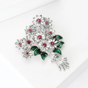 Detail of daisy bouquet brooch with sparkling crystals and green enamel leaves