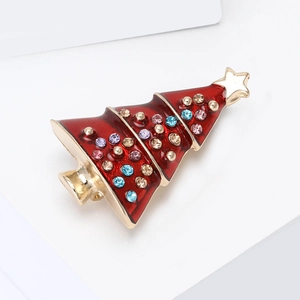 Detail of a Christmas tree brooch with red enamel and colorful rhinestones on a white stand