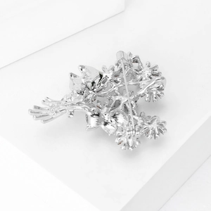 Detailed back view of silver daisy brooch showing a secure safety pin clasp design