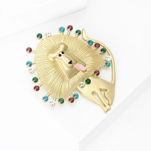 Artistic golden lion brooch with colorful gemstones and mane rays on white background